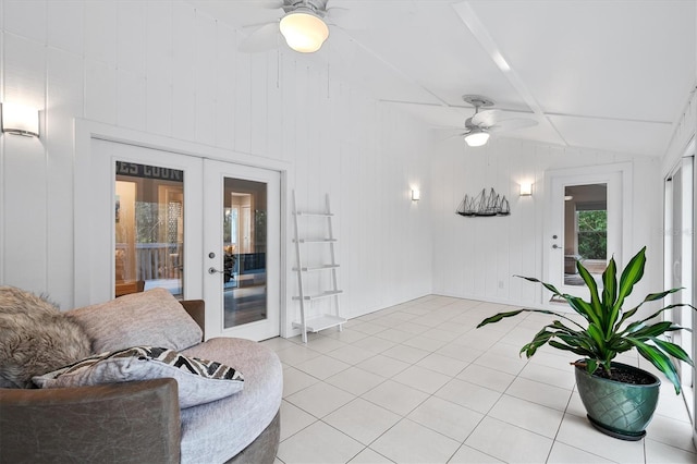 tiled living room featuring french doors, ceiling fan, and vaulted ceiling