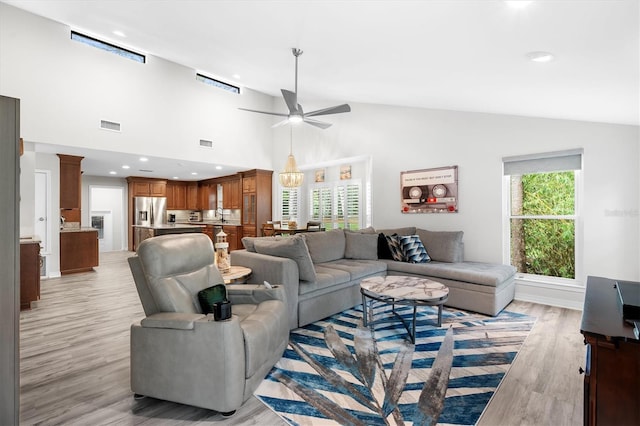 living room with high vaulted ceiling, light hardwood / wood-style floors, and ceiling fan