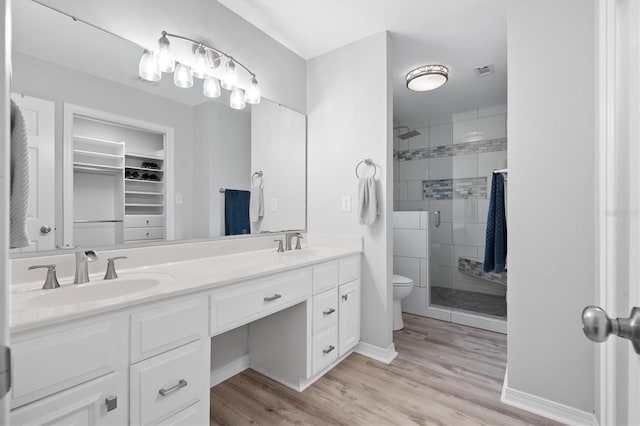 bathroom with hardwood / wood-style flooring, vanity, an enclosed shower, and toilet