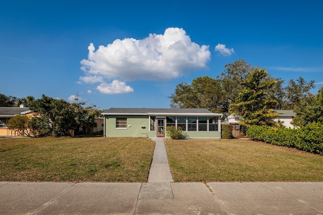 ranch-style home featuring a sunroom and a front lawn