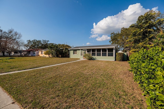 ranch-style house with a front yard and a sunroom