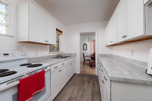 kitchen featuring dark hardwood / wood-style floors, white electric range, white cabinetry, sink, and hanging light fixtures