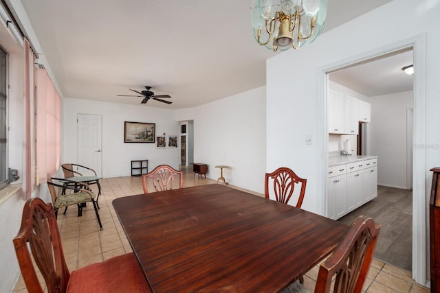 tiled dining room featuring a barn door and ceiling fan with notable chandelier