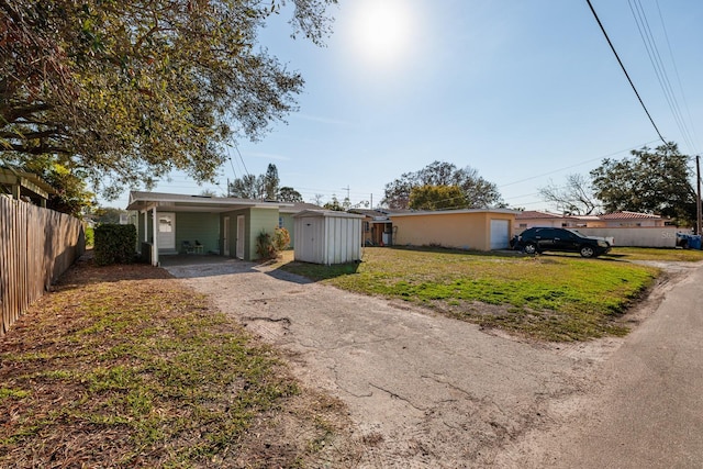 ranch-style home featuring a carport and a front yard