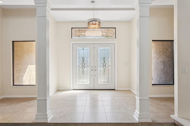 tiled foyer entrance with french doors, beam ceiling, and ornate columns