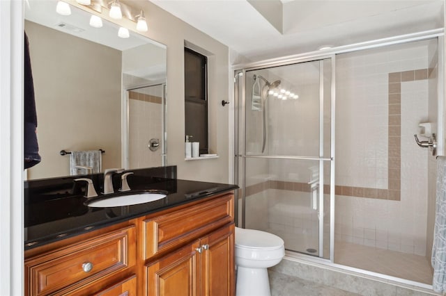 bathroom with vanity, tile patterned floors, a shower with door, and toilet