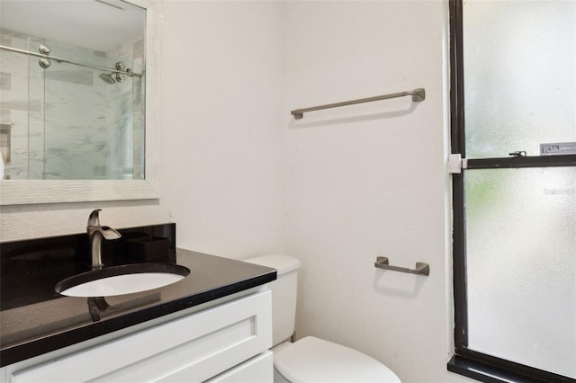 bathroom featuring vanity, toilet, and walk in shower