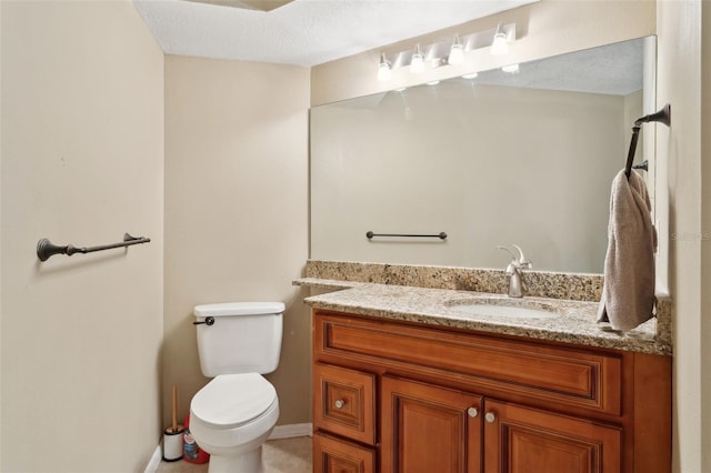 bathroom with vanity, a textured ceiling, and toilet