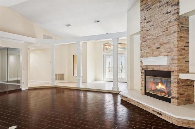 unfurnished living room featuring ornate columns, high vaulted ceiling, hardwood / wood-style flooring, and a fireplace