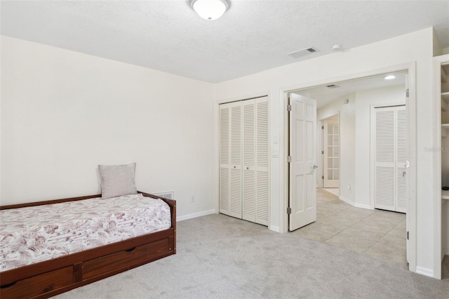 carpeted bedroom featuring a textured ceiling and a closet