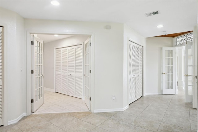 hallway with light tile patterned floors and french doors