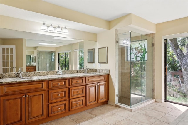 bathroom featuring a shower with door, vanity, and tile patterned flooring