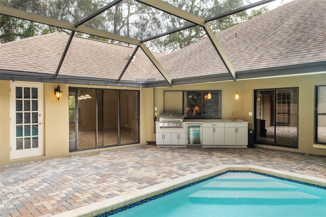 view of pool featuring an outdoor kitchen, a grill, and a patio area