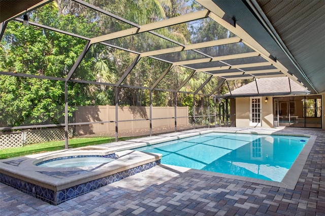 view of pool with a lanai, a patio, and an in ground hot tub