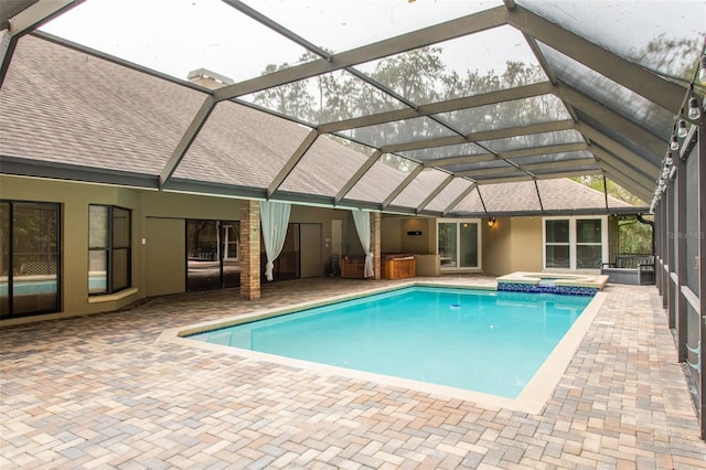 view of swimming pool featuring an in ground hot tub, a patio area, and glass enclosure