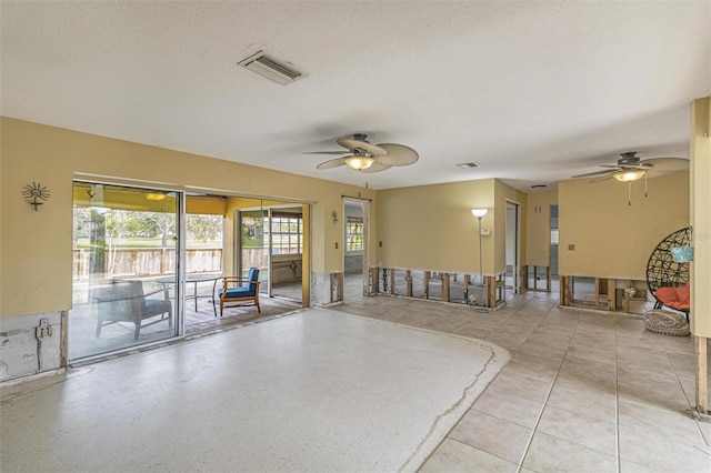 interior space with ceiling fan and a textured ceiling