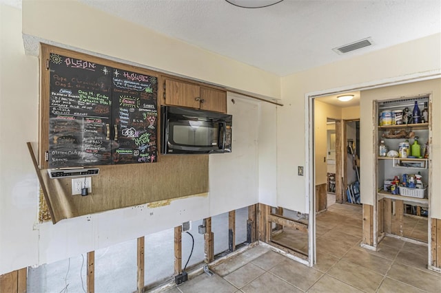 kitchen with light tile patterned flooring and a textured ceiling