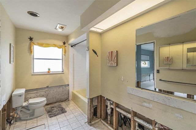 bathroom with shower / tub combination, tile patterned floors, and toilet