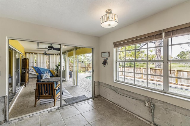 doorway to outside featuring a textured ceiling and light tile patterned floors