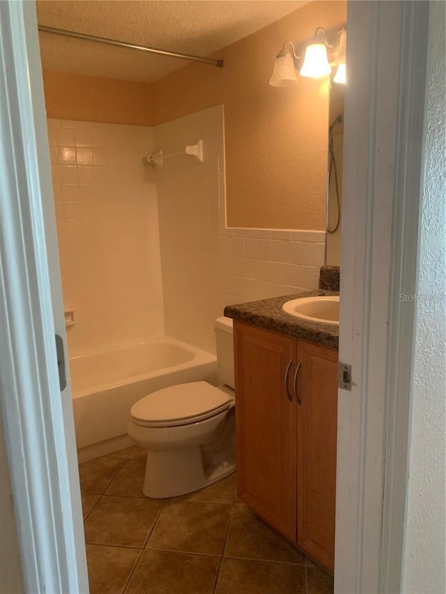 full bathroom featuring tile walls, tile patterned flooring, vanity, toilet, and a textured ceiling