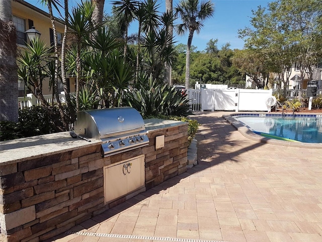 view of patio / terrace with exterior kitchen, area for grilling, and a fenced in pool