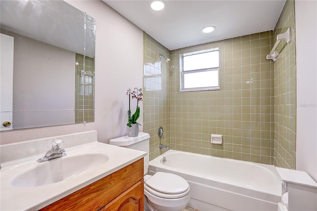 full bathroom with tiled shower / bath, vanity, and toilet