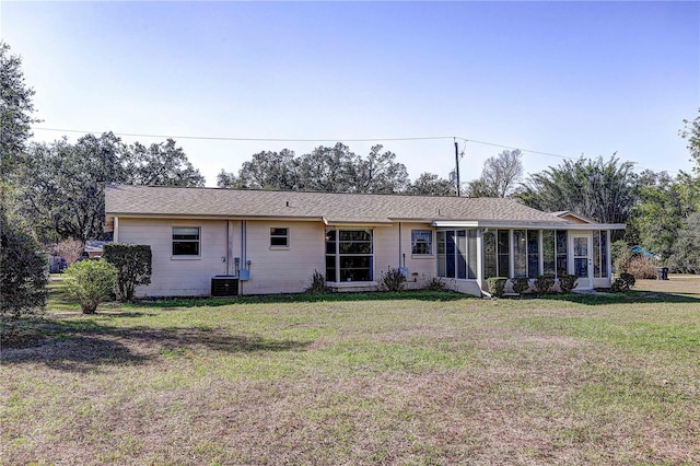 view of front facade featuring cooling unit, a front yard, and a sunroom