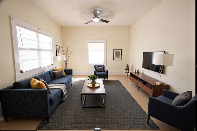 tiled living room with a wealth of natural light and ceiling fan