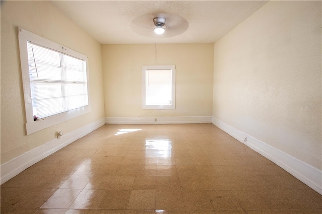 empty room with a wealth of natural light and ceiling fan