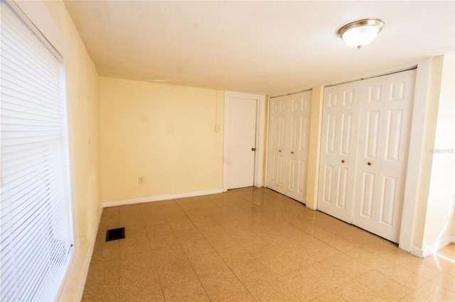 unfurnished bedroom featuring multiple closets