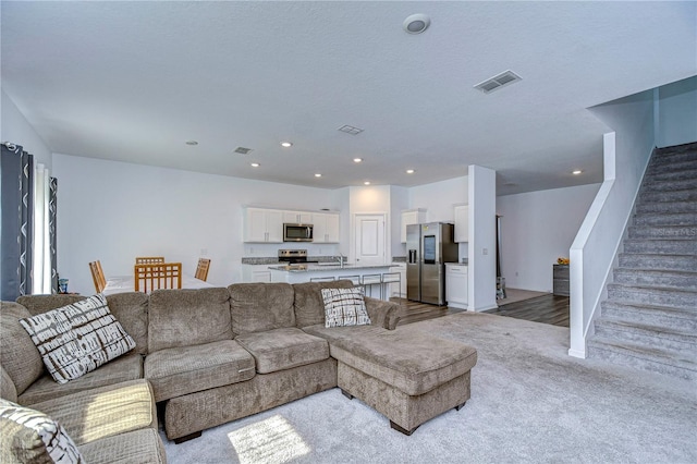 living room featuring sink and a textured ceiling