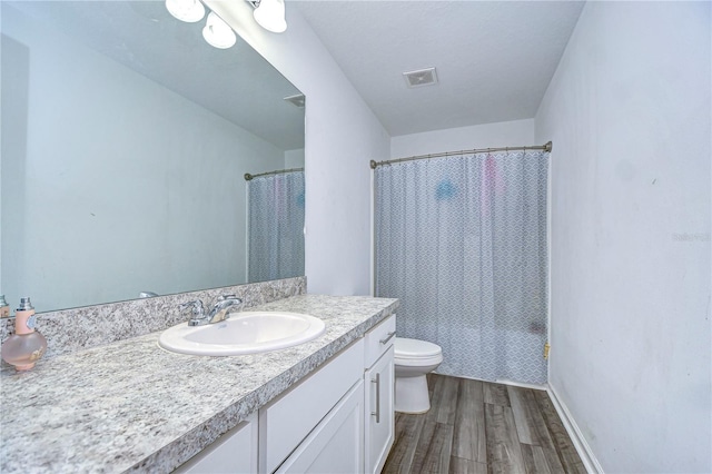 full bathroom featuring vanity, hardwood / wood-style floors, shower / bathtub combination with curtain, and toilet