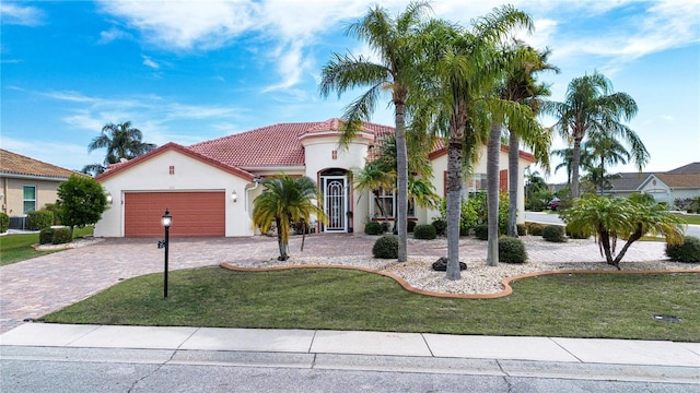 mediterranean / spanish house featuring a garage and a front lawn