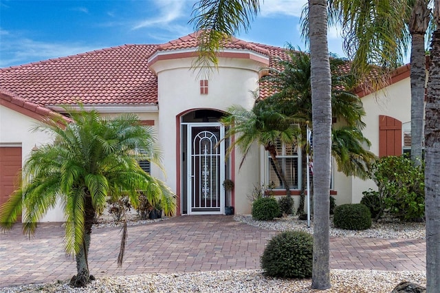 doorway to property with a tiled roof and stucco siding