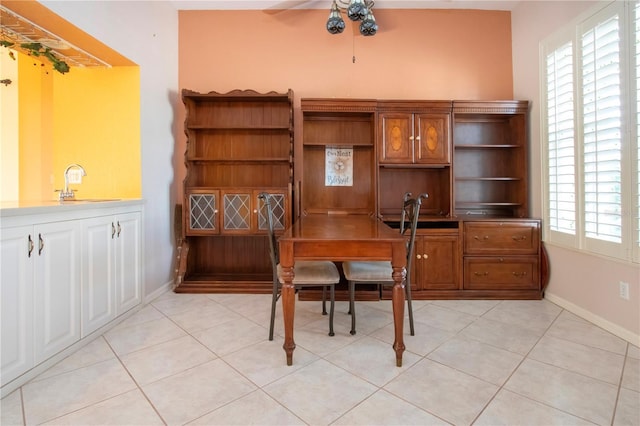 office featuring light tile patterned floors, a sink, a ceiling fan, and baseboards