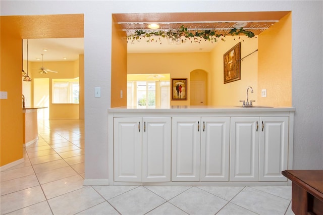 bathroom with baseboards, tile patterned flooring, a ceiling fan, and a sink