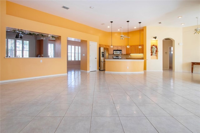 unfurnished living room featuring a healthy amount of sunlight, visible vents, ceiling fan, and light tile patterned flooring