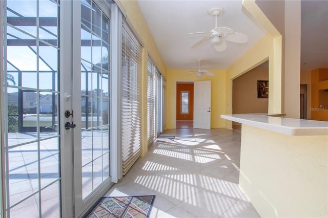 doorway to outside featuring light tile patterned floors and ceiling fan