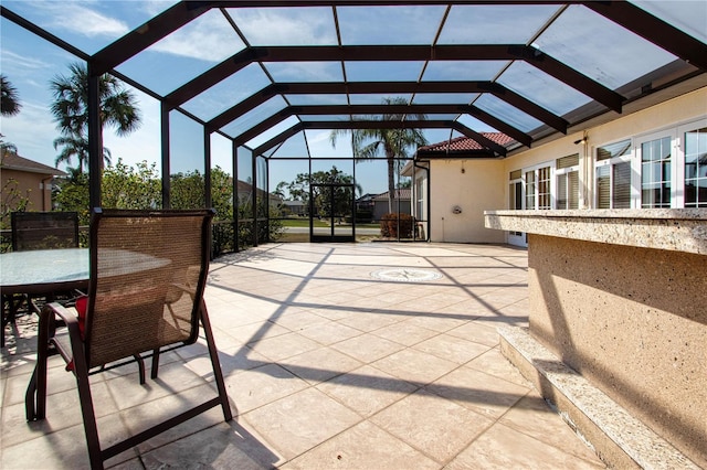 view of patio / terrace featuring glass enclosure and outdoor dining space