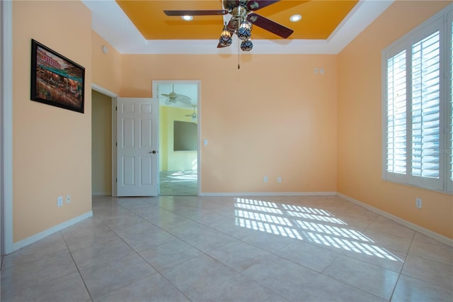 tiled empty room with baseboards, a tray ceiling, and recessed lighting