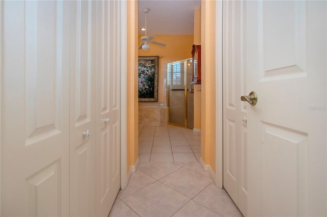 hallway with light tile patterned flooring and baseboards