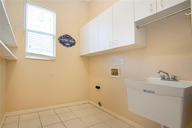 clothes washing area with hookup for a washing machine, cabinet space, a sink, and baseboards