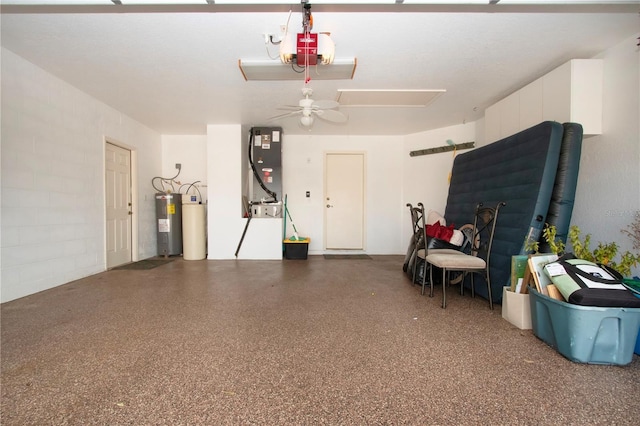 garage featuring heating unit, concrete block wall, electric water heater, and a garage door opener