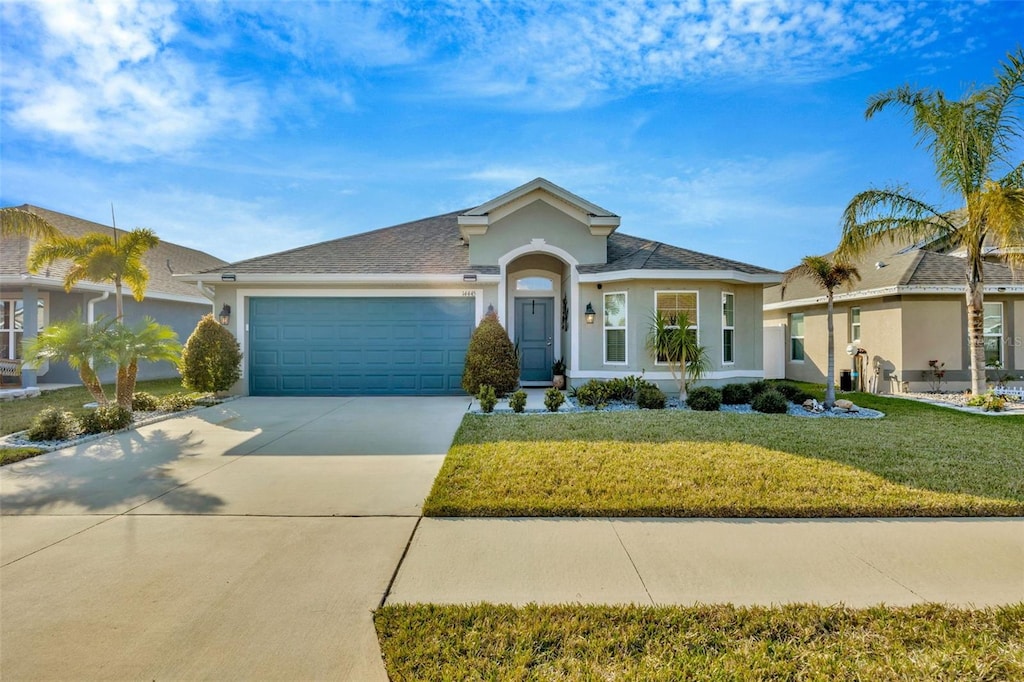 ranch-style home featuring a garage and a front lawn