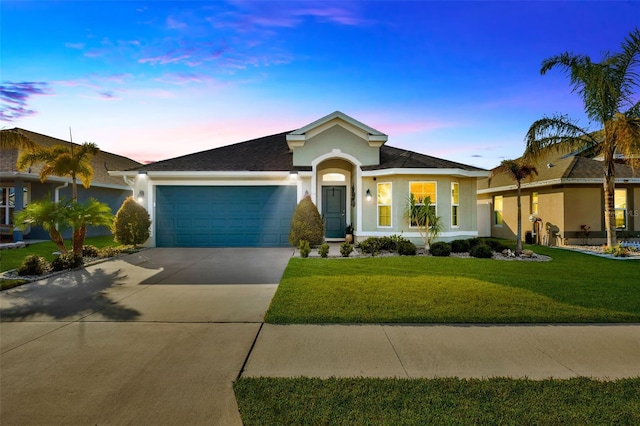 ranch-style house with a garage and a yard