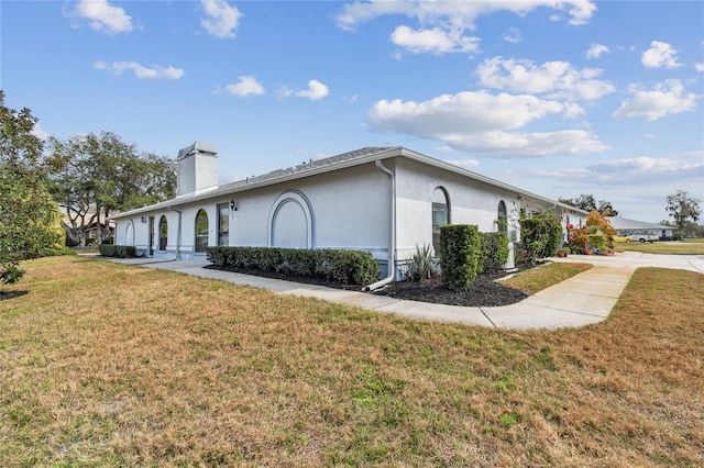 view of side of home with a lawn