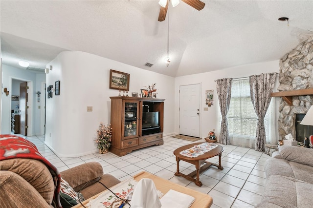 living room featuring lofted ceiling, light tile patterned floors, ceiling fan, a fireplace, and a textured ceiling