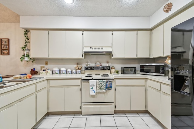 kitchen featuring black fridge, white electric range, a textured ceiling, and light tile patterned floors