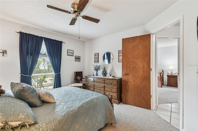 bedroom with ceiling fan, light carpet, and a textured ceiling