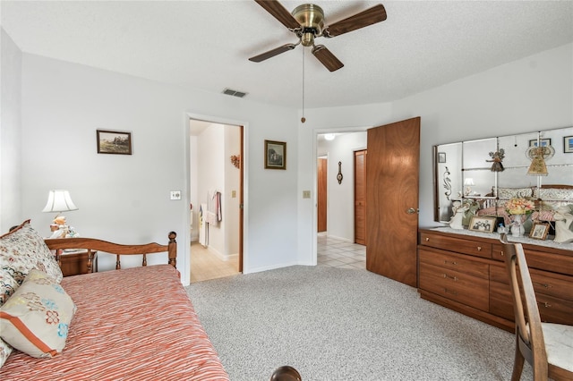 carpeted bedroom featuring ceiling fan and a textured ceiling